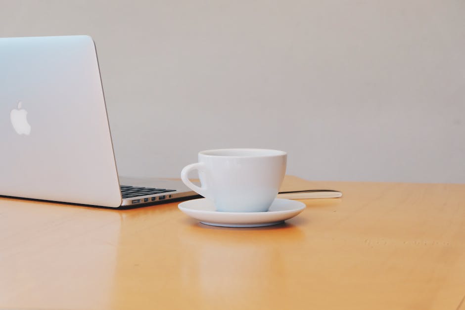 Laptop and coffee cup on table